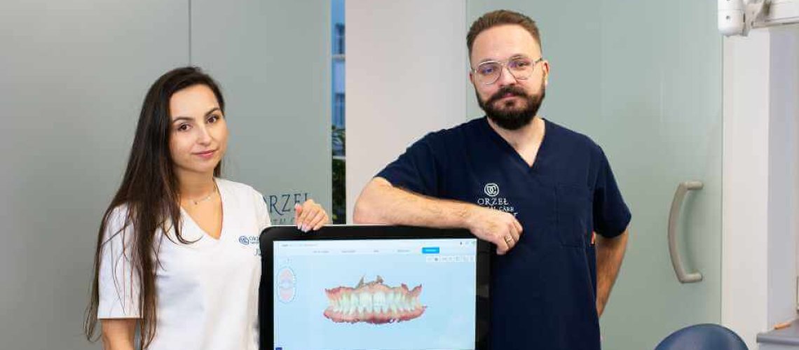 Lekarz Invisalign wraz z asystentką ortodontyczną stoją obok skanera wewnątrzustnego iTero Invisalign